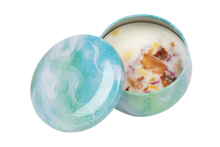 Blue decorative candle tin that includes dried flowers in the soy wax