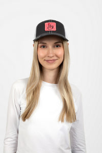 Woman wearing dark gray ILY baseball cap with pink patch - front
