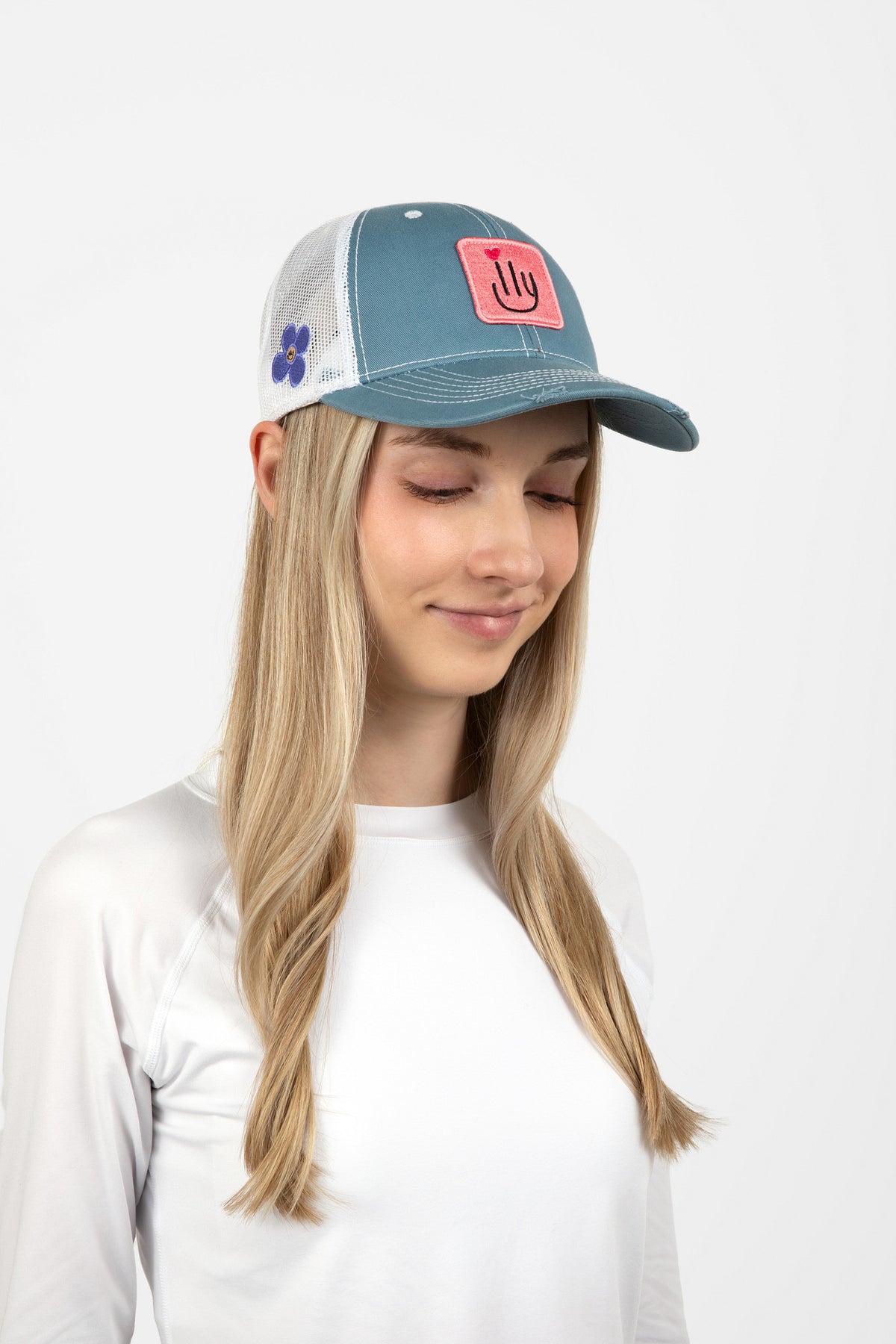 Woman wearing a light blue baseball cap with a pink ILY logo - Side view