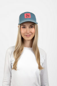 Woman wearing a light blue baseball cap with a pink ILY logo - Front view