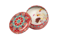 Red decorative candle tin that includes dried flowers in the soy wax