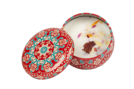 Red decorative candle tin that includes dried flowers in the soy wax