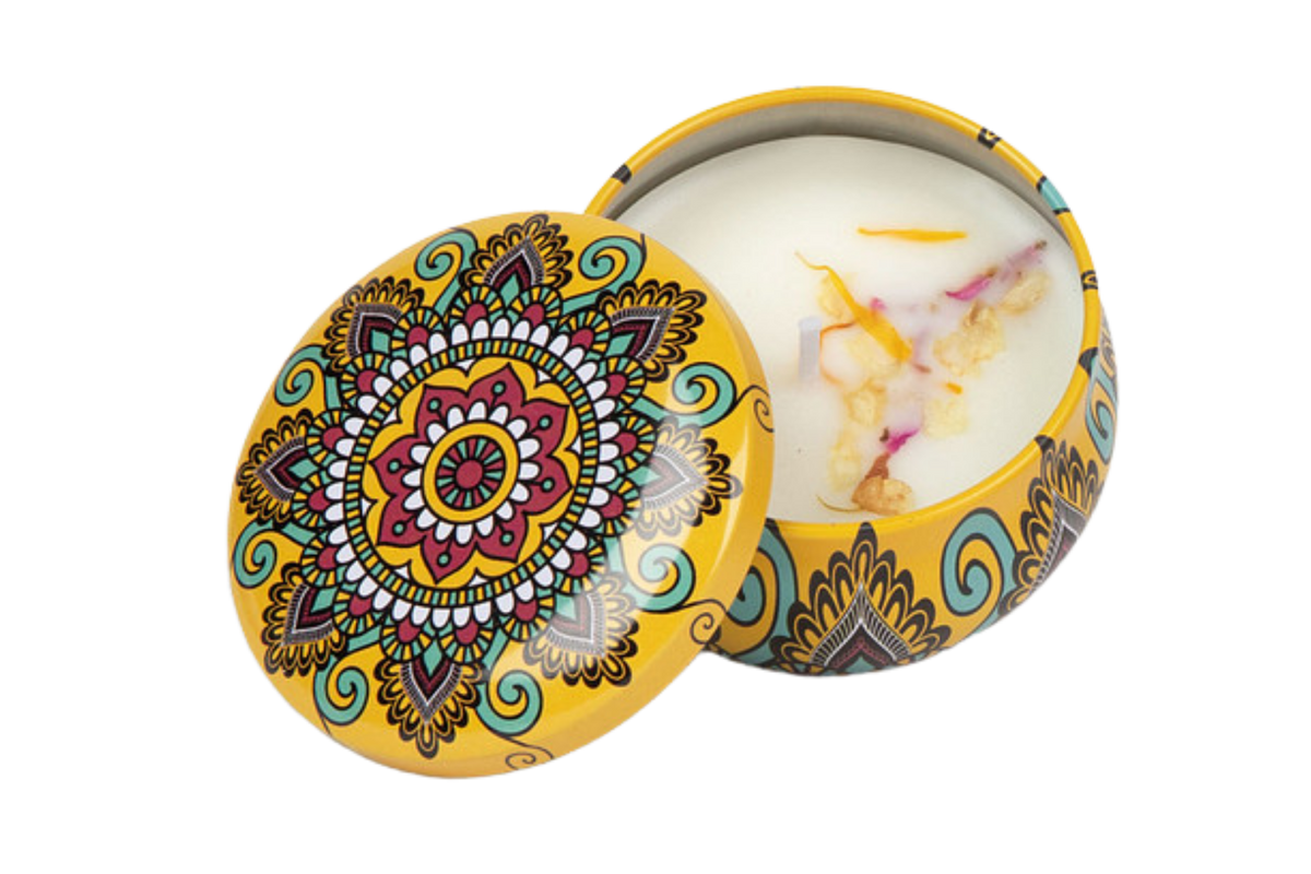 Yellow decorative candle tin that includes dried flowers in the soy wax